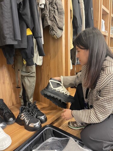  Min 在為客戶挑選適合的鞋子。